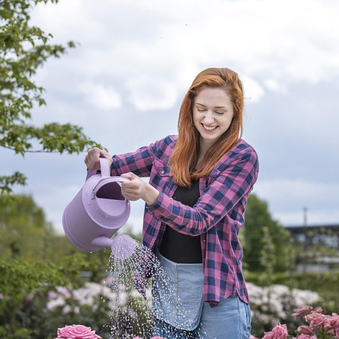 Frau gießt Rosen